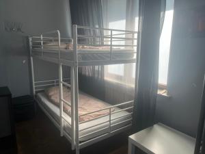 two bunk beds in a room with a window at 4 Couples & 4 Friends Hostel in Kraków