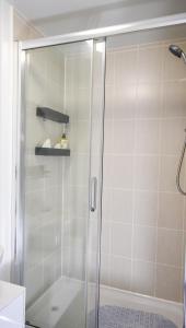 a shower with a glass door in a bathroom at 3 Bedroom House close to city centre in Liverpool