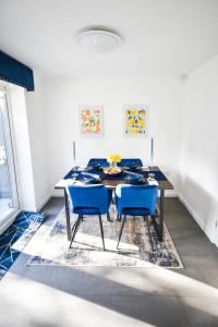 a dining room with a table and two blue chairs at 3 Bedroom House close to city centre in Liverpool