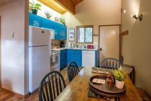 a kitchen with a table and a white refrigerator at Escape To Ptarmigan Village 86 in Whitefish