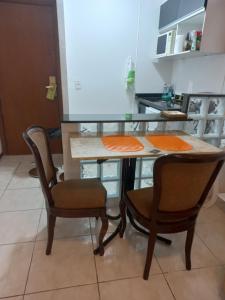 a kitchen with a table and two chairs at Flat The Time - Brooklin in São Paulo