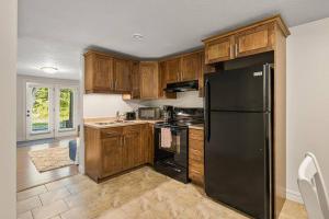 a kitchen with a black refrigerator and wooden cabinets at Quite 1 bedroom apartment. in Dieppe