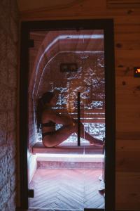 a woman sitting on a window sill in a room at 9CENTO B&B and Private SPA in Montenero Val Cocchiara