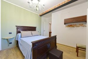 - une chambre avec un lit et un lustre dans l'établissement Casa Valentina 1902, à Montegrosso dʼAsti