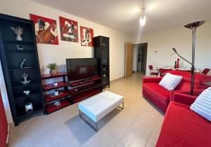 a living room with a red couch and a tv at Spacious 1 bed, terrace, garden, Colindale St in Colindale