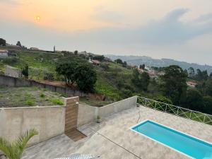 une vue d'une piscine depuis une maison dans l'établissement Chácara Por do Sol, à Serra Negra
