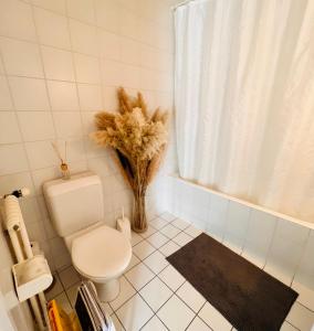 a bathroom with a toilet and a vase of flowers at Le Cottage in Vésenaz