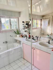 a white bathroom with two sinks and a tub at Le Cottage in Vésenaz