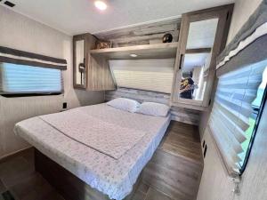 Camper de Camaseyes في أغواديلا: غرفة نوم في مقطورة مع سرير ومرآة