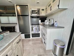 a kitchen in an rv with a stainless steel refrigerator at Camper de Camaseyes in Aguadilla