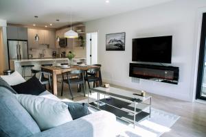 een woonkamer met een bank en een eetkamer bij Ski & Tee Retreat Bright Three Bedroom and Hot Tub in Revelstoke