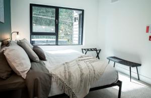 a white bedroom with a bed and a window at Ski & Tee Retreat Bright Three Bedroom and Hot Tub in Revelstoke
