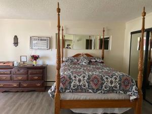 een slaapkamer met een hemelbed en een dressoir bij Lake Front Cottage-Sleeps 8-Free Kayaks-Pets OK! 