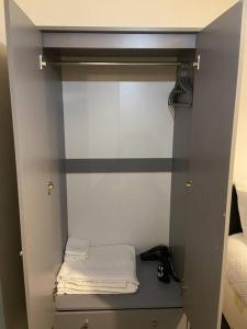 a small closet with a shelf with towels on it at Modern 3 Bed House in Dagenham