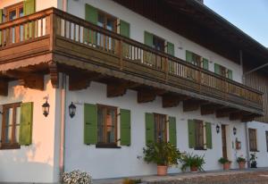 ein Gebäude mit grünen Rollläden und einem Balkon in der Unterkunft Ferienwohnung beim Hainz in Dietramszell