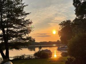 een zonsondergang over een rivier met boten op het water bij Lake Front Cottage-Sleeps 8-Free Kayaks-Pets OK! 
