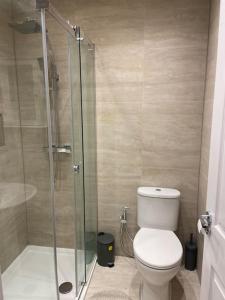 a bathroom with a toilet and a glass shower at Modern 3 Bed House in Dagenham