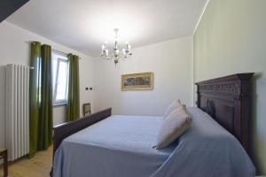 - une chambre avec un lit et un lustre dans l'établissement Casa Valentina 1902, à Montegrosso dʼAsti