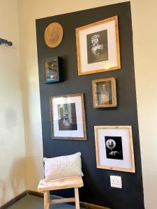 a wall with pictures on it with a wooden chair at Industrial farm stay in Polokwane in Eerstegoud