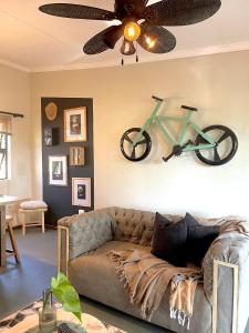 a living room with a couch with a bike on the wall at Industrial farm stay in Polokwane in Eerstegoud