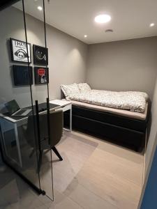 een kleine kamer met een bed en een bureau bij Luxury penthouse apt with amazing views in Svolvær