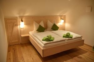 ein Schlafzimmer mit einem Bett mit zwei grünen Handtüchern darauf in der Unterkunft Ferienwohnung beim Hainz in Dietramszell