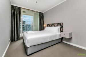 - une chambre avec un grand lit et une grande fenêtre dans l'établissement QV Luxury with Sea Views (1128), à Auckland