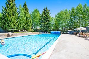 a large swimming pool with trees in the background at Windriver Retreat in Teton Village