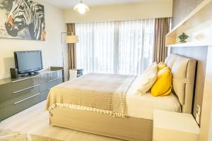 a hotel room with a bed and a television at Downtown Oasis - Spacious Modern 3-BR Flat near Beachpark in Antalya
