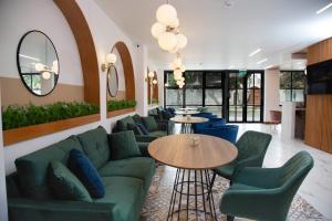 ein Wohnzimmer mit einem grünen Sofa und blauen Stühlen in der Unterkunft Hotel San Blas in Lima