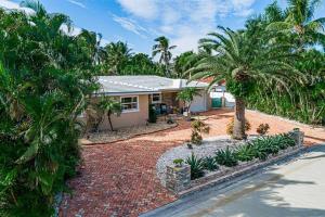 a house with palm trees and a brick driveway at Beach Paradise * 5 mins walk to beach *chef kitchen *private pool in Riviera Beach
