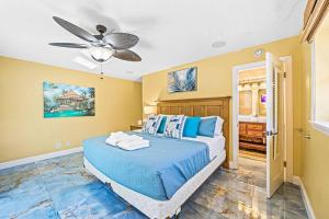 een slaapkamer met een blauw bed en een plafondventilator bij Beach Paradise * 5 mins walk to beach *chef kitchen *private pool in Riviera Beach