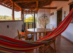 a hammock in a room with a table and chairs at Hotel Casa El Mandarino By MH in Barichara