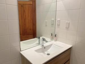 Merivale four bedroom house في كرايستشيرش: حمام مع حوض أبيض ومرآة