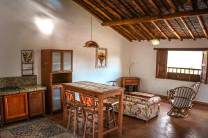 a kitchen and living room with a table and a couch at Hotel Casa El Mandarino By MH in Barichara