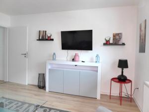 a living room with a tv on a white wall at Paris Winterberg Ferienwohnung 6 Pers WiFi in City near Lift in Winterberg