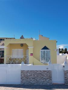 una casa con una cerca blanca delante de ella en Min 26 en Caleta de Fuste