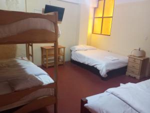 1 dormitorio con 2 literas y vestidor en ALOJAMIENTO PICSHA EXPEDITIONS, en Huaraz