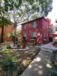 a red house with trees in front of it at Departamento Tucán in Cancún