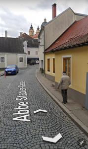 un hombre caminando por una calle con un cartel que dice lento en Altstadthaus Marille mit Innenhofterrasse, en Melk