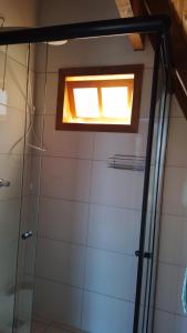 een badkamer met een douche en een raam bij Chalé Cachoeira do Túnel- Linda vista da Serra da Mantiqueira in Delfim Moreira