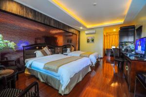 Habitación de hotel con 2 camas y TV de pantalla plana. en Interpark Hotel en Olongapo