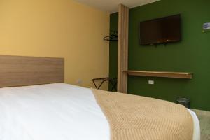 a bedroom with a bed and a flat screen tv at NOVO Hotel Boutique in Ríohacha