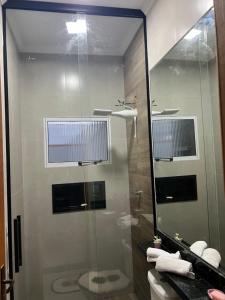 een badkamer met een glazen douche en een toilet bij Casa da mãe Aparecida. in Pindamonhangaba