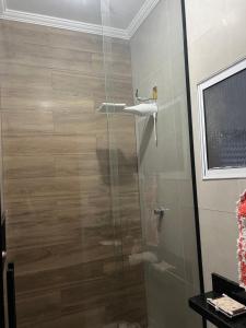 een douche met een glazen deur in de badkamer bij Casa da mãe Aparecida. in Pindamonhangaba