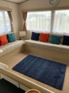 a living room with a couch with colorful pillows at Highway in Lossiemouth