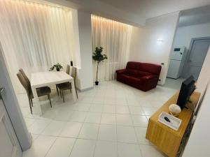 Amikales Rooms في بادوفا: غرفة معيشة مع أريكة حمراء وطاولة