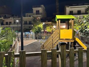 a small yellow playground in a city at night at Rania's House in Piraeus