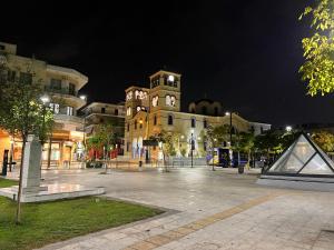 a large building with a clock tower at night at Rania's House in Piraeus