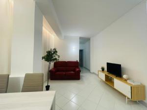 Amikales Rooms في بادوفا: غرفة معيشة بها أريكة حمراء وتلفزيون